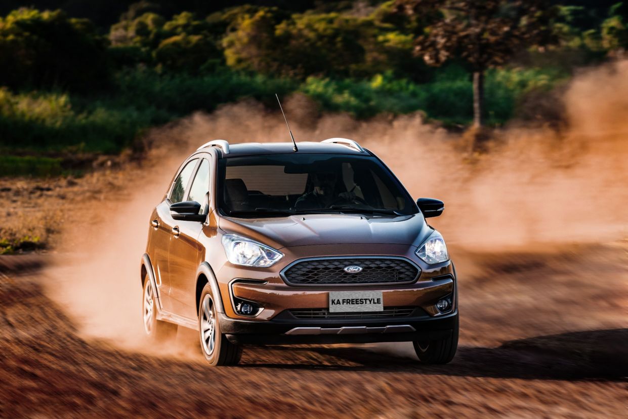 ford ka freestyle marrom de frente em movimento levantando poeira