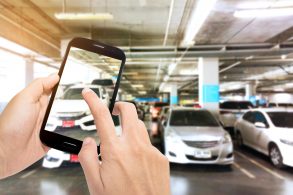 Pessoa com celular na mão fotografando seu automóvel para vendê-lo na internet