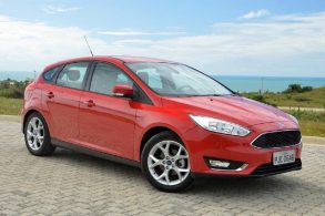 Ford focus hatch vermelho estacionado em frente ao mar