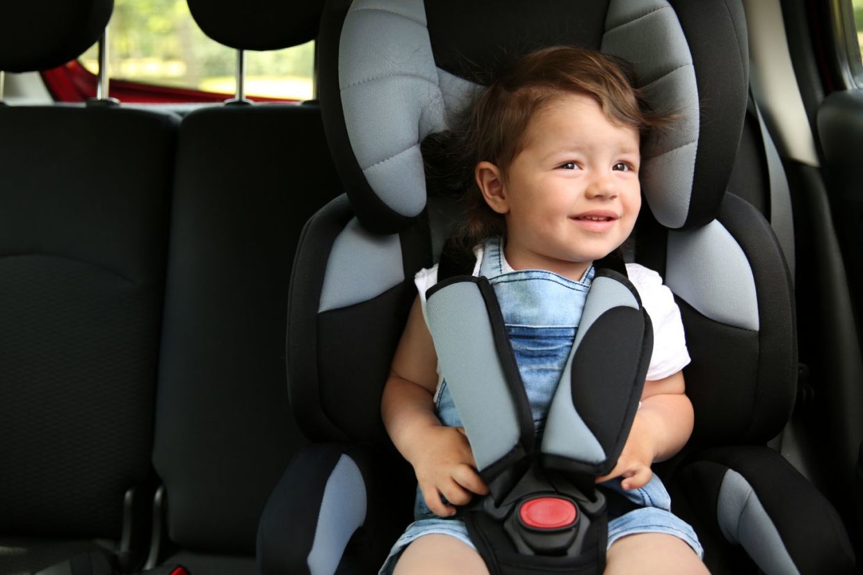 criança sentada em cadeirinha no carro