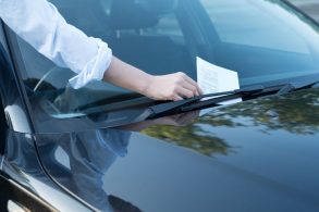 Homem pega advertência por escrito no para-brisa do carro multas de trânsito