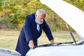 homem olhando defeito em motor de carro shutterstock