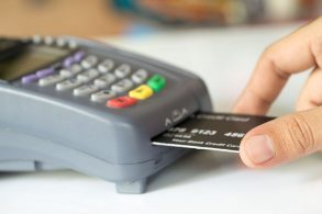 mão humana insere cartão preto em máquina