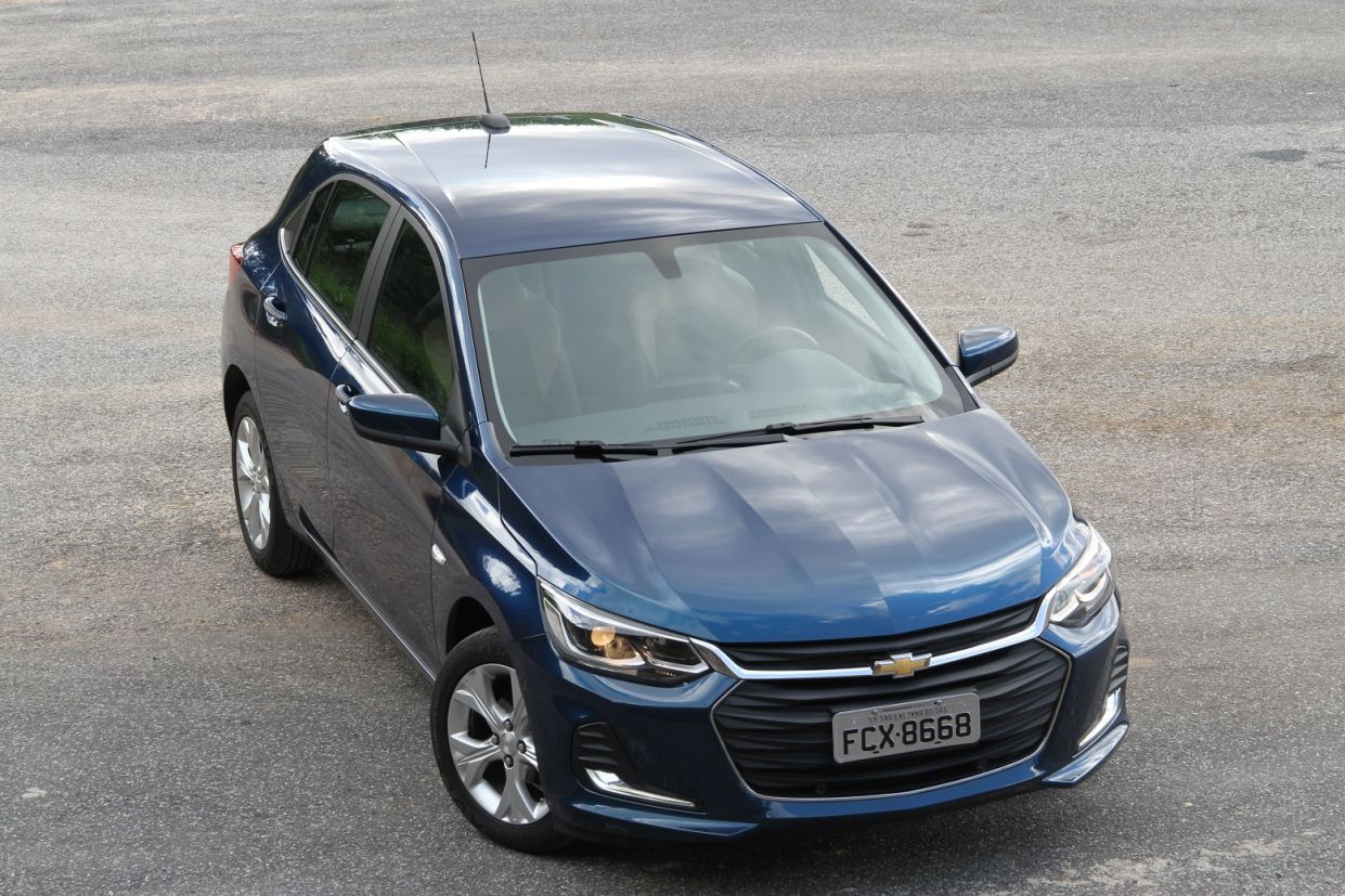 carros automáticos mais econômicos no segmento de compactos: chevrolet onix 2020 hatch azul visto a partir da dianteira