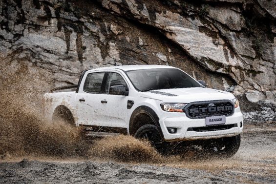 ford ranger 2020 storm na cor branca em uma estrada de terra vista pela dianteira em tres quartos com uma montanha ao fundo