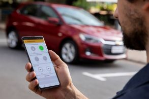 motorista acessando sistema onstar chevrolet celular gm onix vermelho fundo