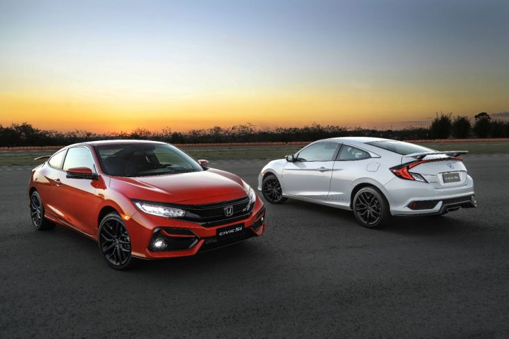 dois honda civic si nas cores vermelho e branco estacionados em pista de corrida mostrando dianteira e traseira do modelo