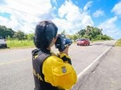 agente do detran com radar movel ou radar portatil em maos na beira de rodovia no para 1