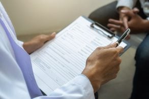 medico com prancheta na mao faz exames de aptidao fisica e mental em paciente