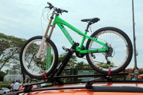 bicicleta verde presa em suporte no teto de um taxi em curitiba