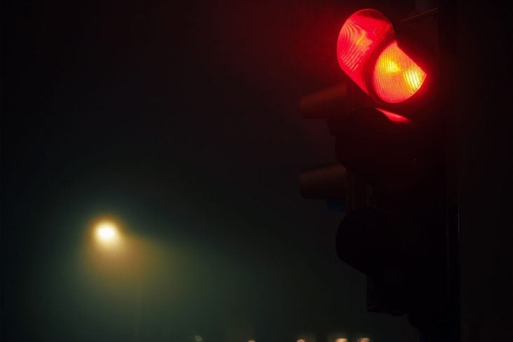 semaforo com sinal vermelho em noite escura shutterstock