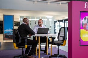 homens negociam carro por assinauta em sala de reuniao do flua foto fca