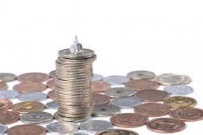 miniatura de um cadeirante ou pessoa com deficiencia pcd sobre moedas representando isenco de impostos como ipva ipi e icms