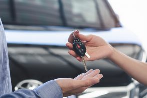 mao de mulher entrega chave de carro para mao de homem