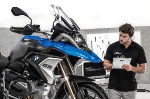 funcionario bmw motorrad com prancheta na mao analisando moto gs azul