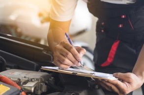 recall obrigatorio mecanico com prancheta capo do carro aberto