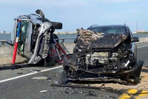 dois carros destruidos em acidente de trânsito sobre uma ponte