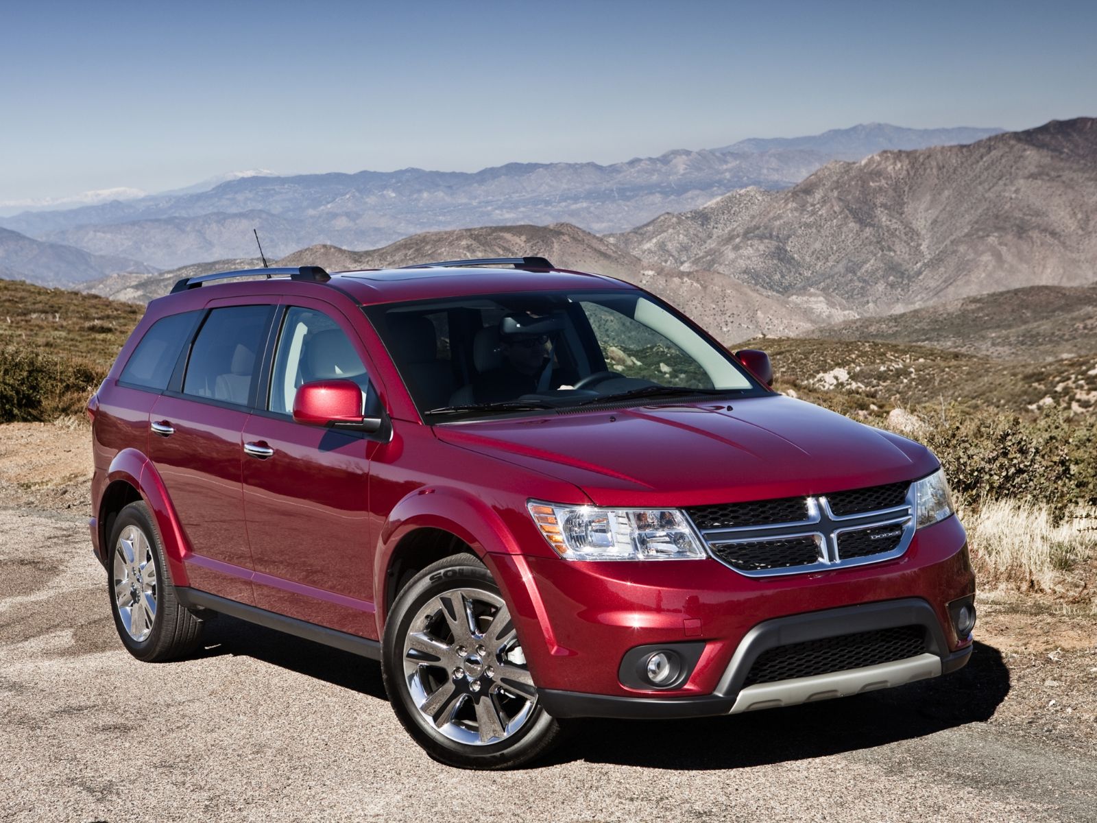 dodge journey vermelho dianteira parado com montanhas ao fundo