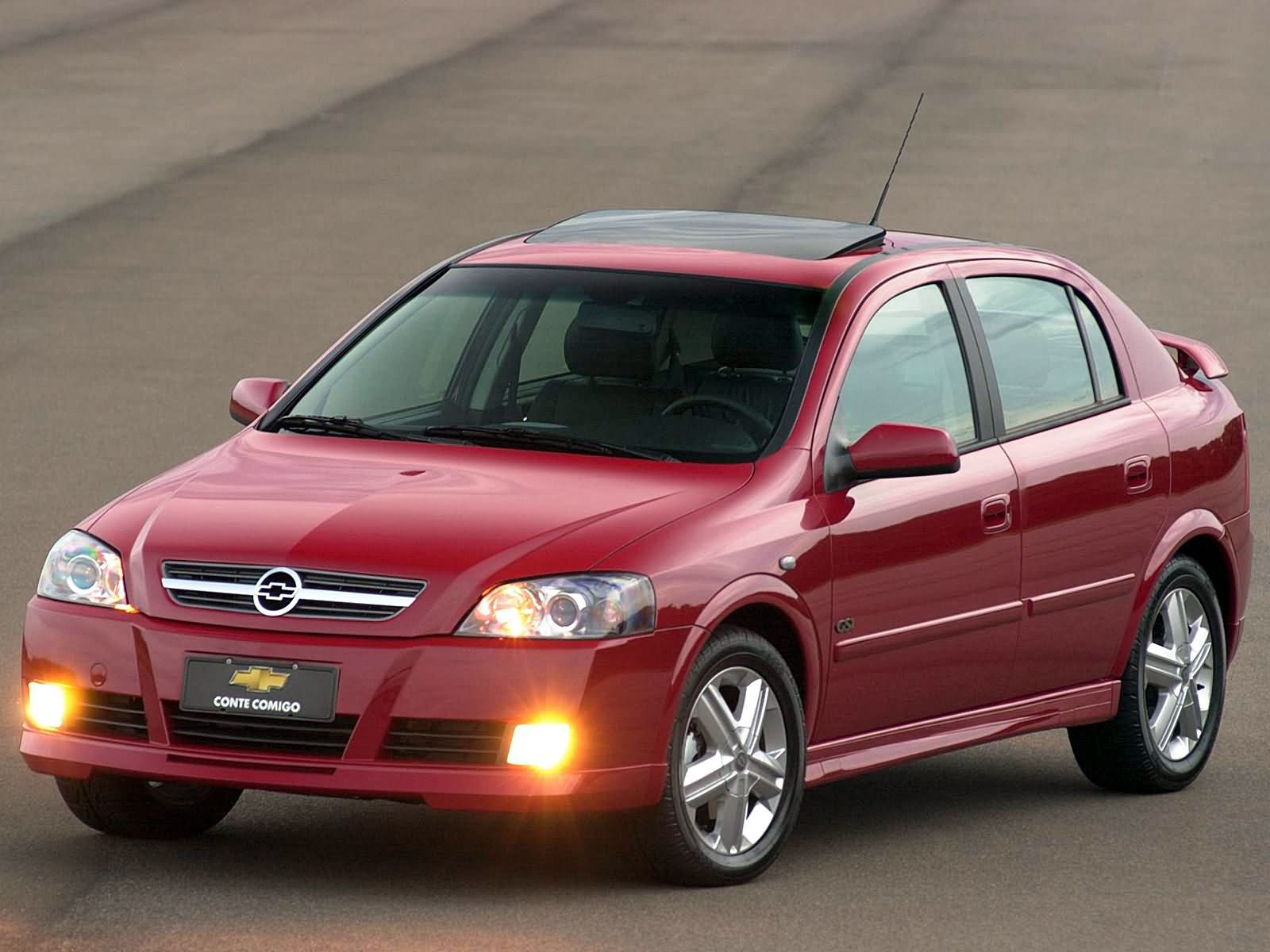 chevrolet astra gsi hatch vermelho de frente com farois acesos