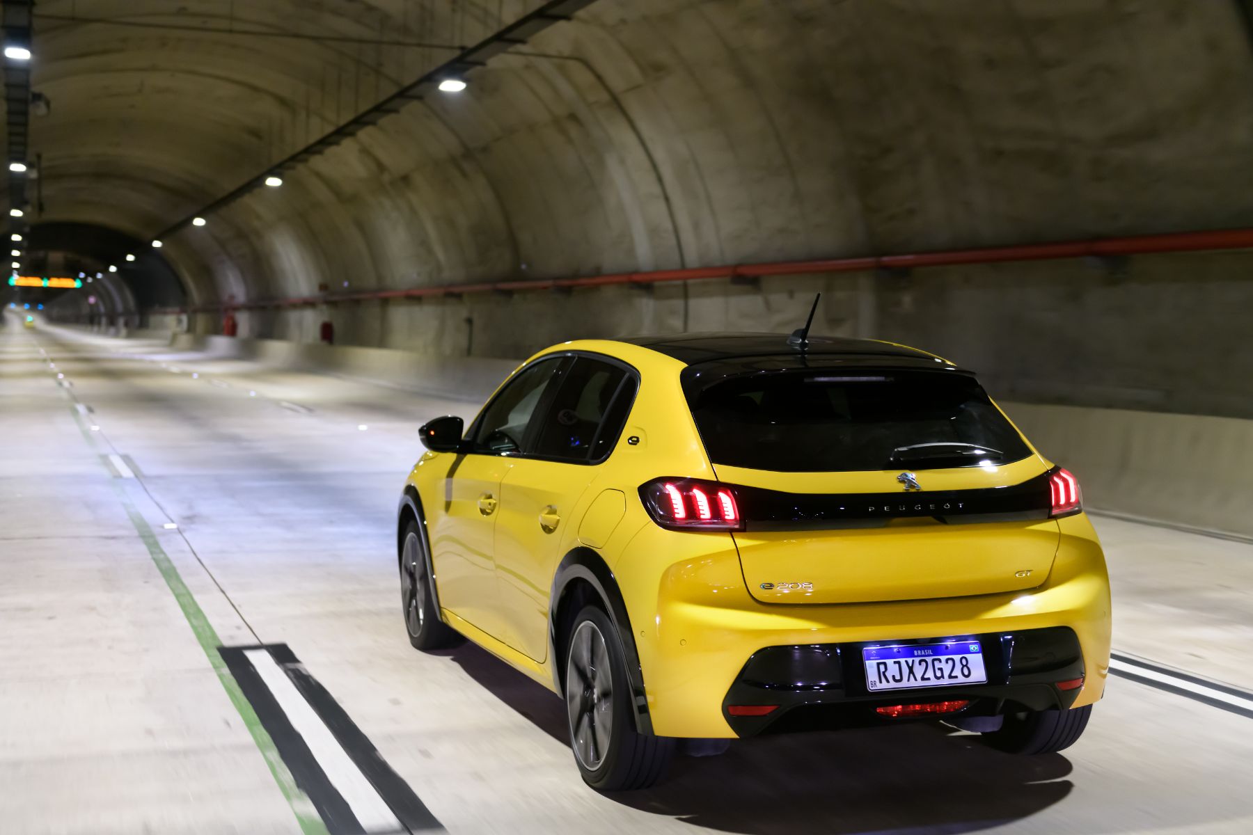 peugeot e 208 gt amarelo traseira em movimento tunel