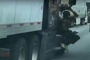 homem flagrado pendurado em retrovisor de carreta