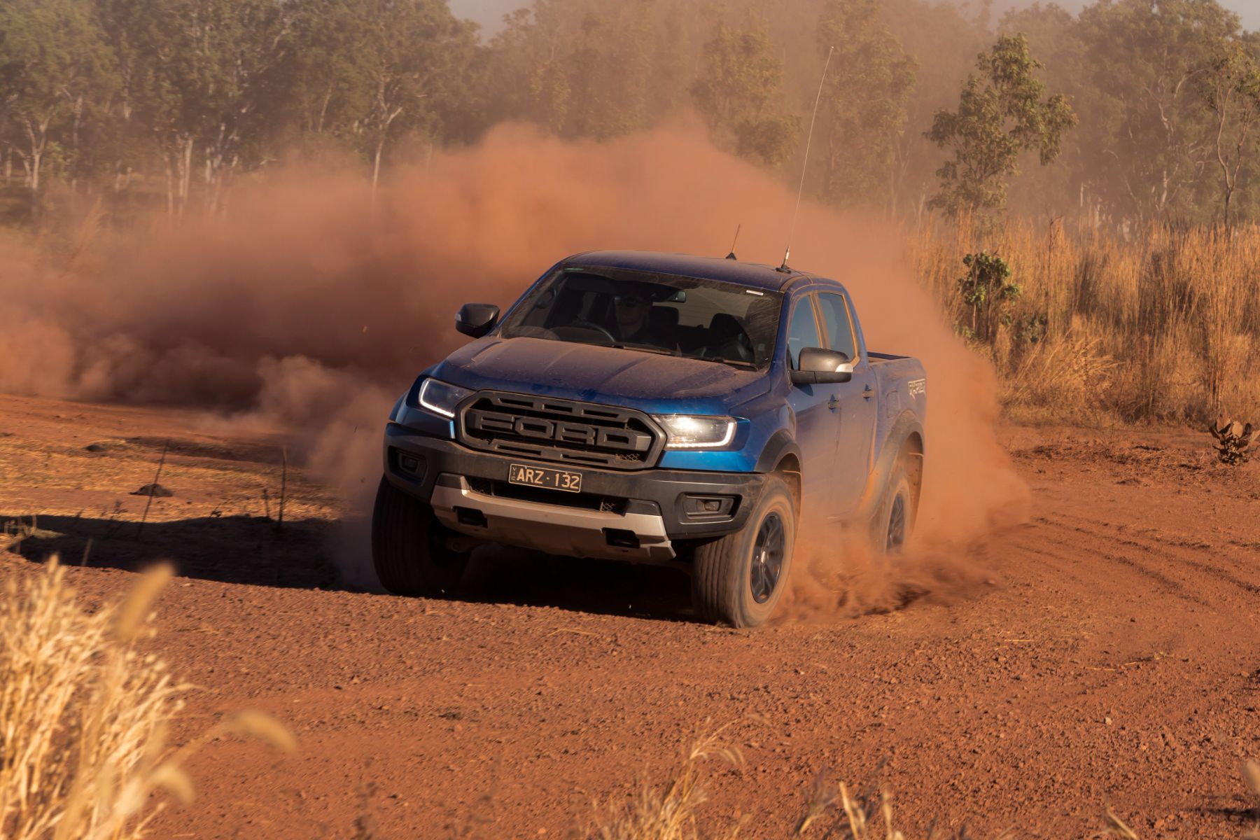 ford ranger raptor azul frente derrapando na terra