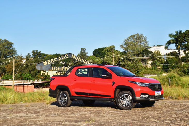 fiat strada ranch vermelha frente parada em estacionamento com calcamento de pedra