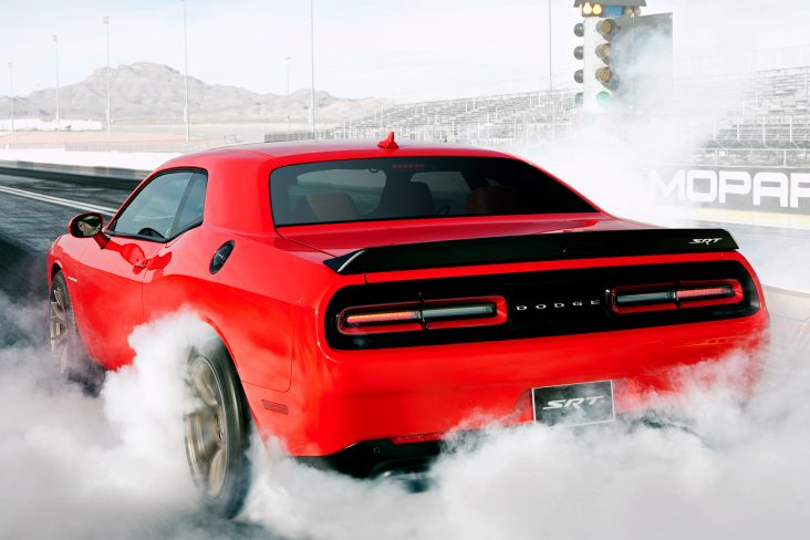 dodge challenger srt hellcat vermelho traseira fazendo um burnout em pista de arrancada