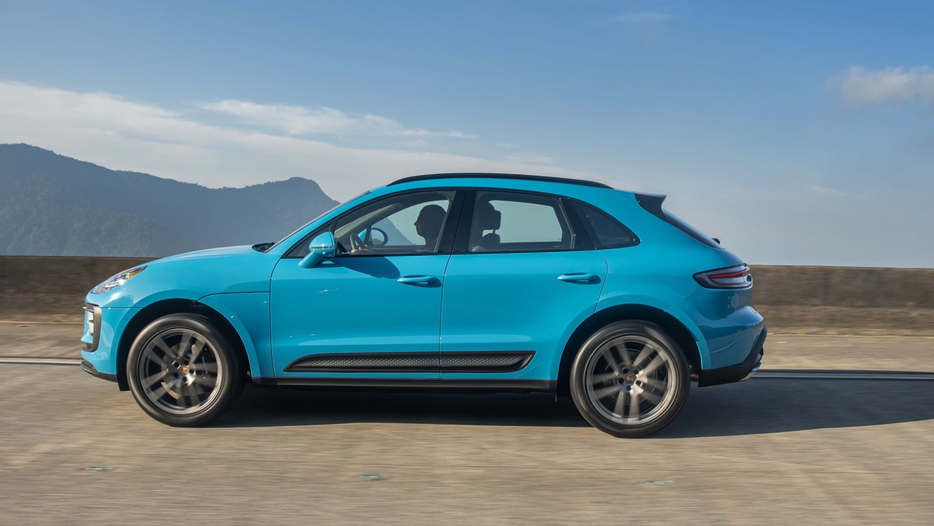 porsche macan azul miami lateral em movimento rodovia