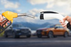 carro hibrido e eletrico bomba gasolina x carregador eletrico carros desfocados ao fundo