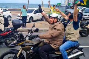 bolsonaro em motociata na bahia salvador com capcete sem visreira e garupa moto bmw f800 gs