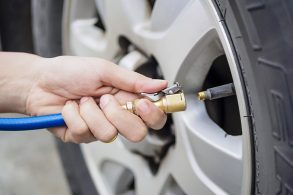 mão feminina com bomba para calibrar o pneu carro