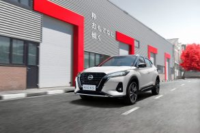 nissan kicks branco em frente a predio cinza com detalhes vermelhos