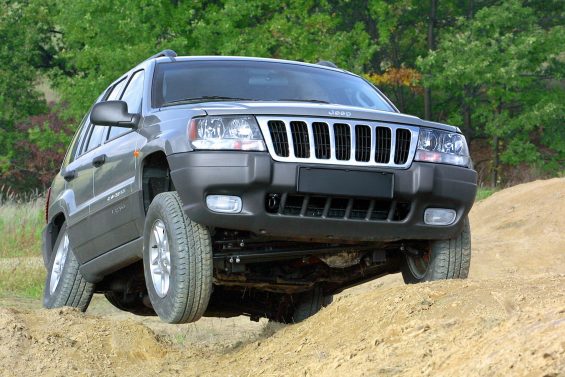 jeep grand cherokee laredo cinza frente em terreno desnivelado com suspensao articulada