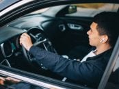shutterstock motorista dirigindo usando fones de ouvido sem fio