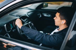 shutterstock motorista dirigindo usando fones de ouvido sem fio