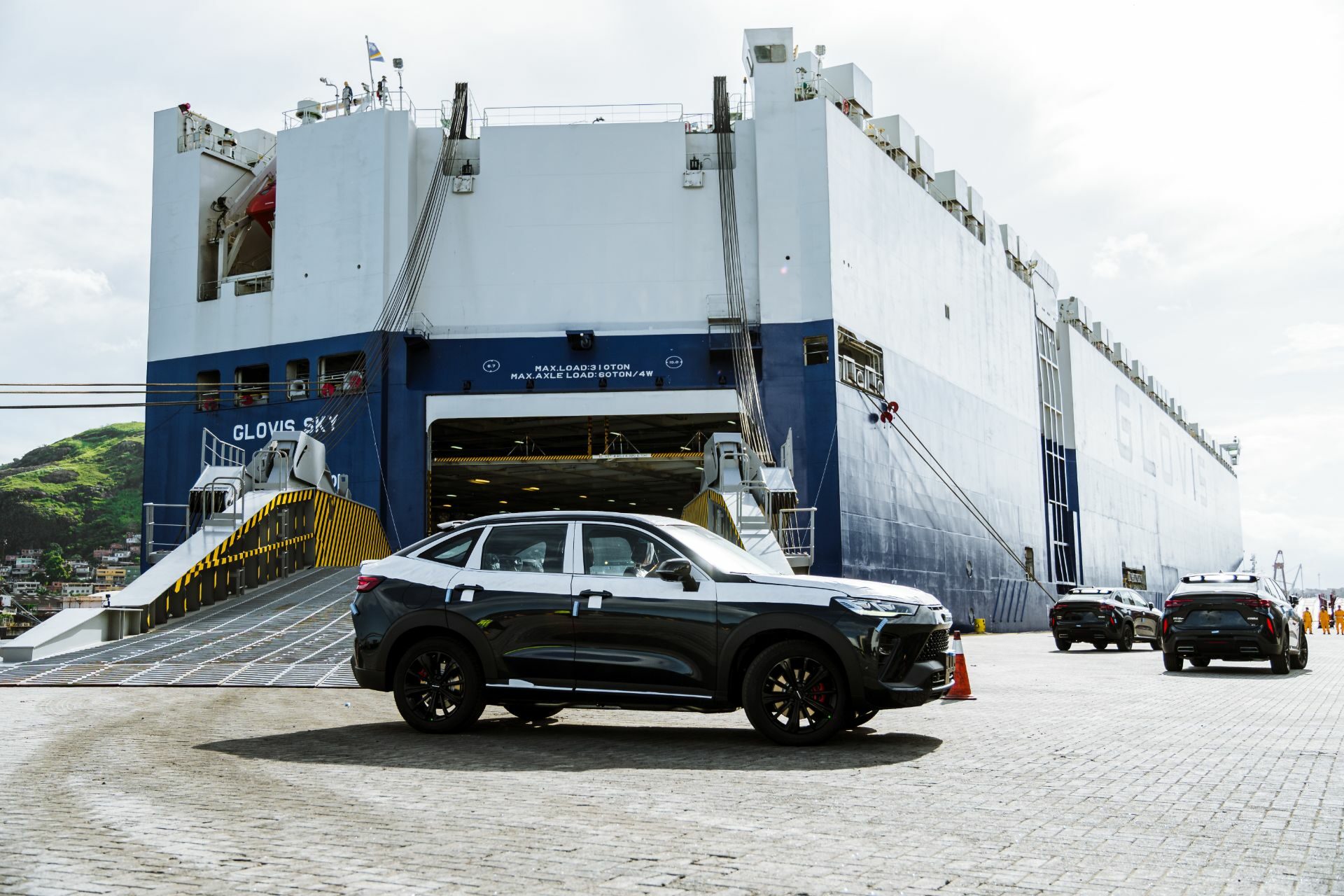 gwm haval h6 gt preto com protecao branca sobre a pintura em porto proximo a navio