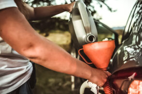 homem colocando aditivo motor carro portal