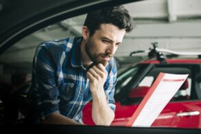 homem lendo contrato compra carro portal - ano modelo