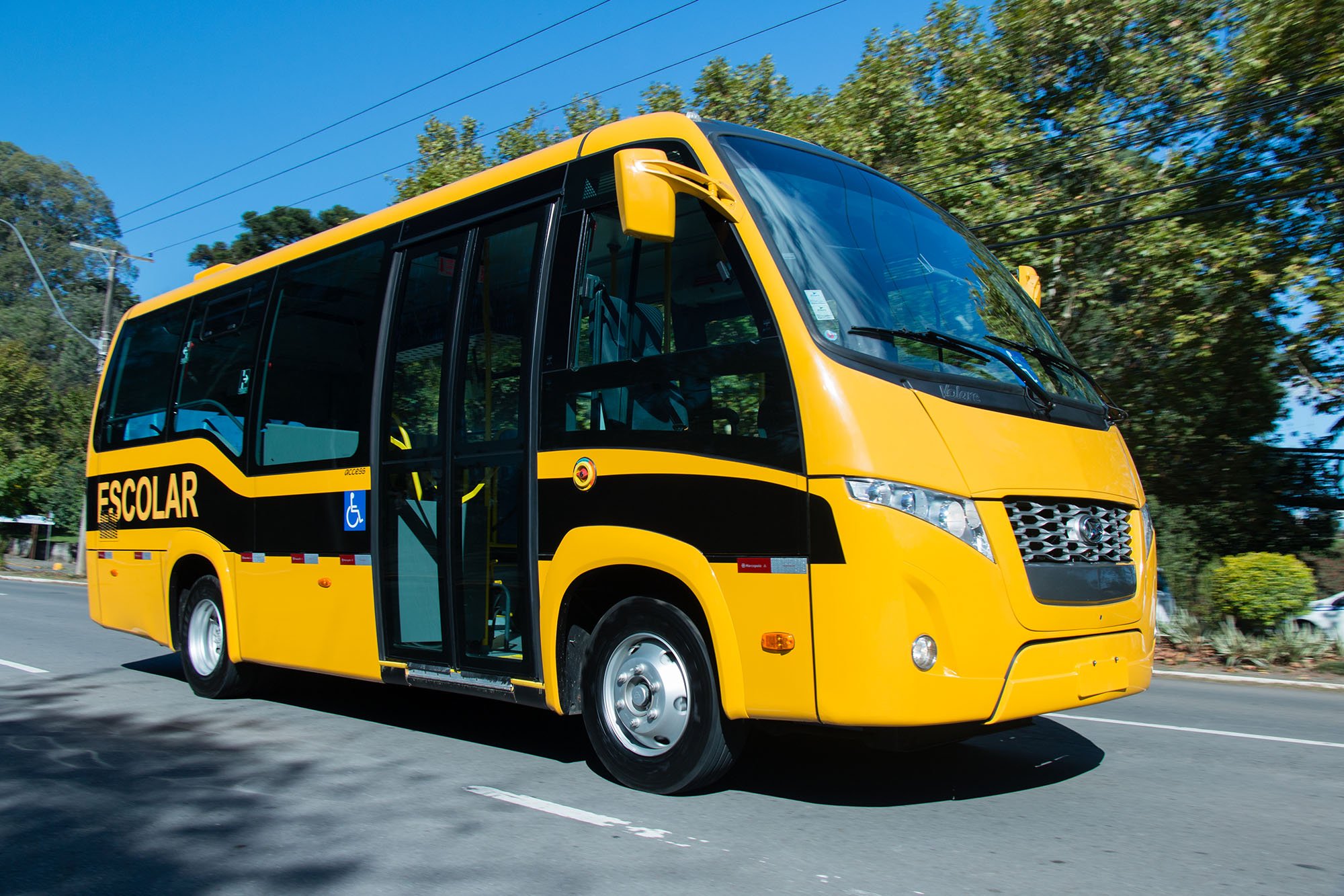 O ônibus escolar amarelo viaja para o prédio da escola através do