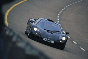 mclaren f1 xp5 preto frente correndo em pista circular