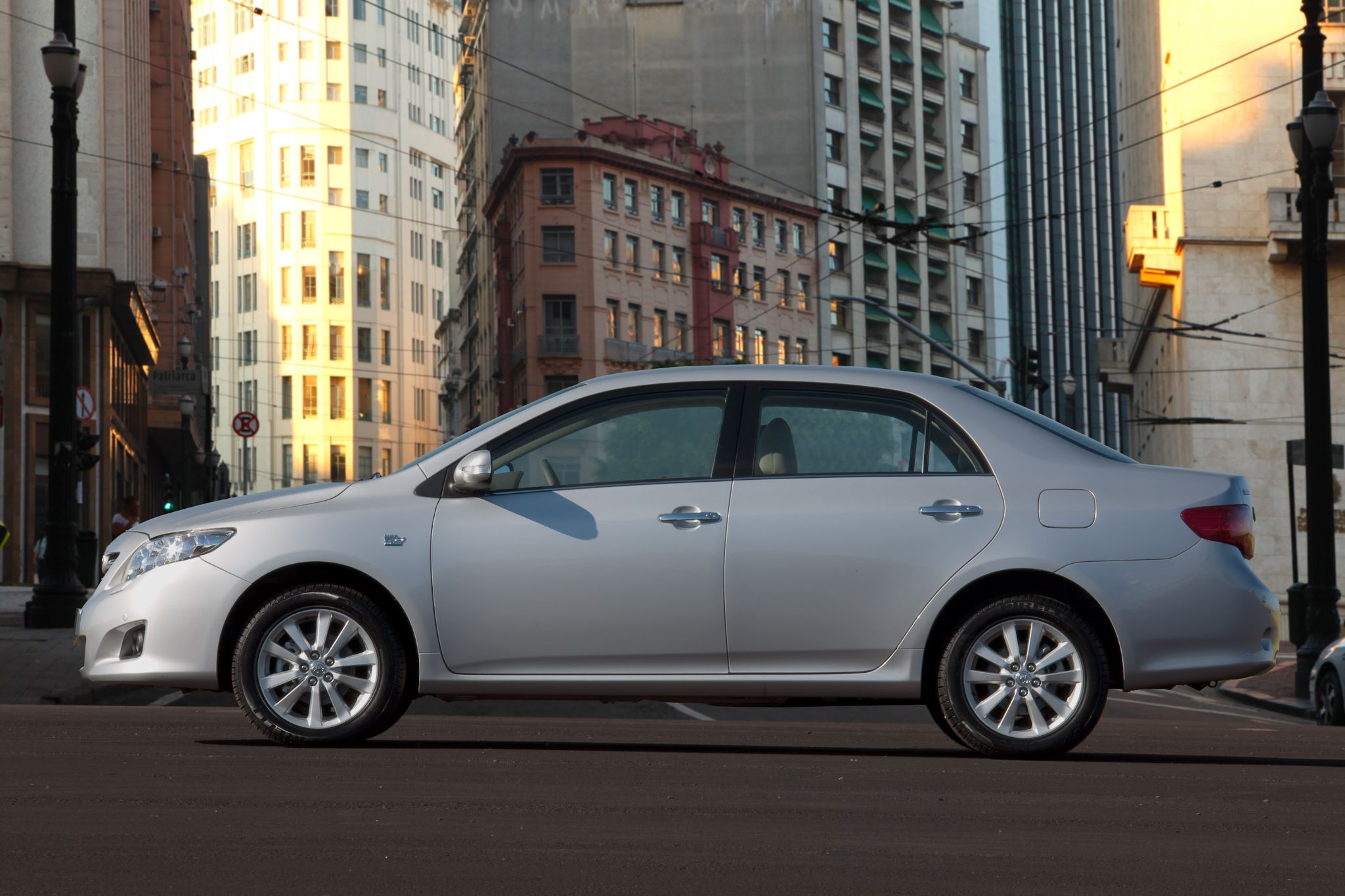 toyota corolla altis prata lateral parado com cidade ao fundo