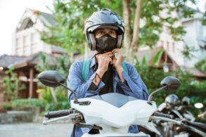 Homem colocando o capacete de motociclista - Aplicativos podem ser obrigados a disponibilizar capacete ao entregador