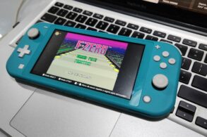 nintendo switch lite azul turquesa sobre macbook reproduzindo f zero