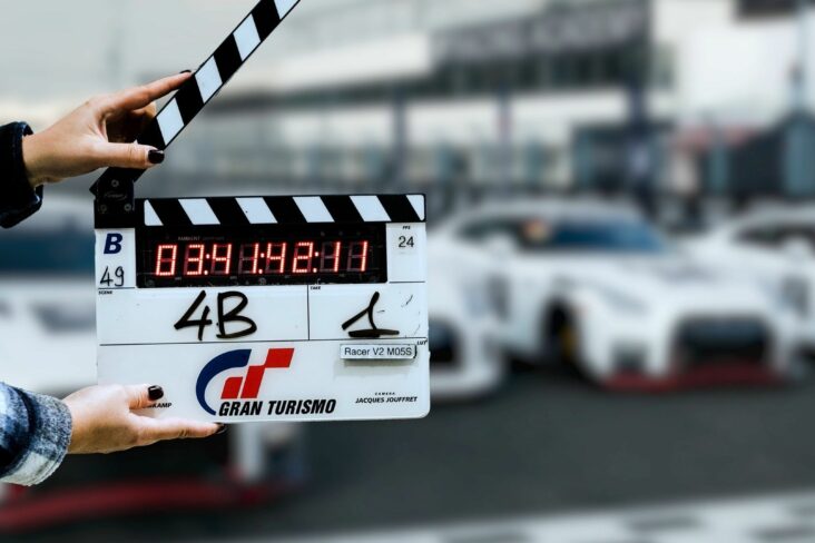 claquete filme gran turismo com nissan gt r desfocado ao fundo