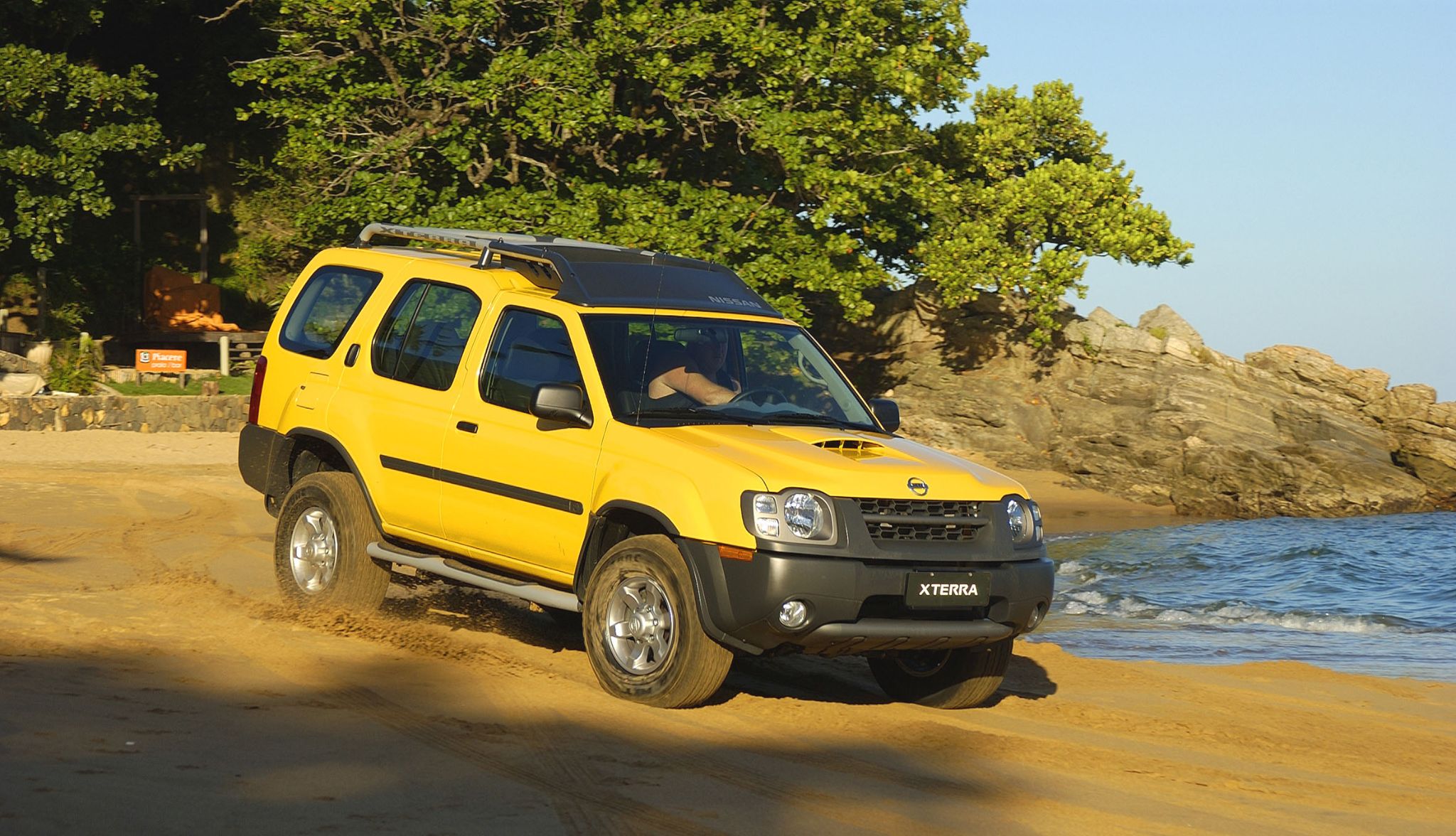 nissan xterra amarela frente parada em praia