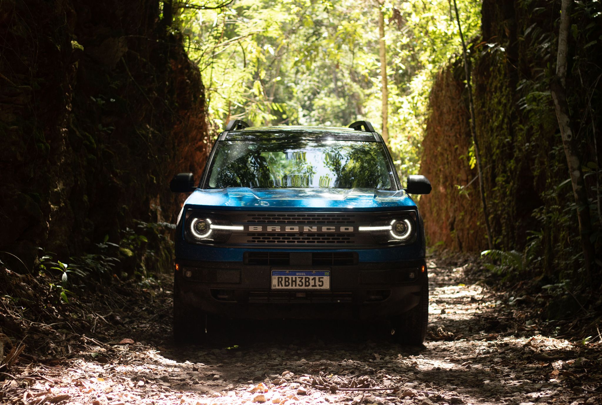 ford bronco sport wildtrak 2022 azul indianapolis frente parado em trilha com sombra de arvores e drl em led ligada