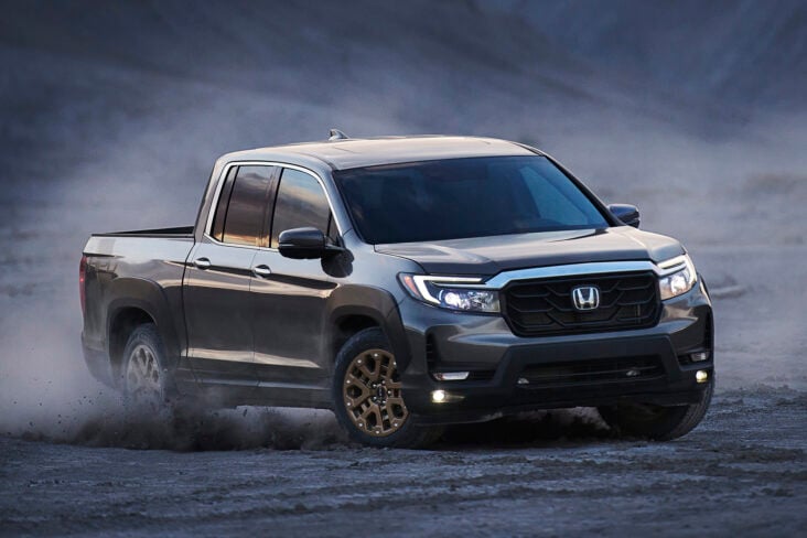 honda ridgeline cinza frente fazendo curva em cascalho