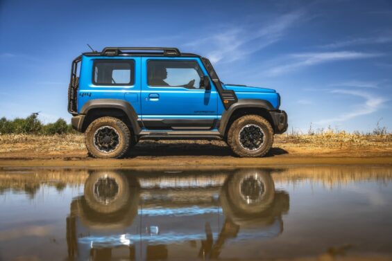 suzuki jimny sierra 4expedition 2024 azul brisk lateral com reflexo em agua