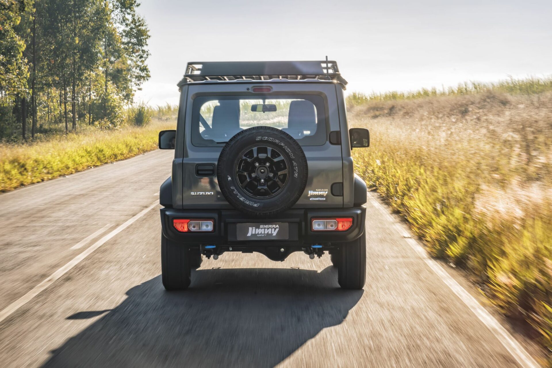 suzuki jimny sierra 4sport 2024 cinza medium traseira parado em rodovia